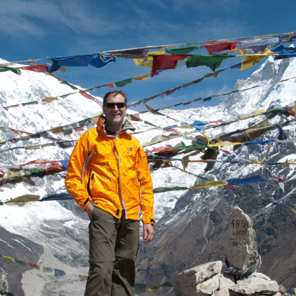 Trekker on top of Kyangjin Ri with Langtang Lirung mountain in the background