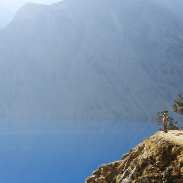 A small trekker in the grand landscape at the Phoksundo lake in Dolpo