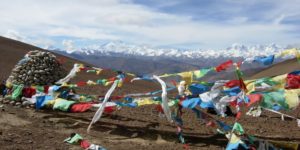 Prayer flags and stones mark the high pass and incredible Himalayan views on the way from Lhasa to Kathmandu